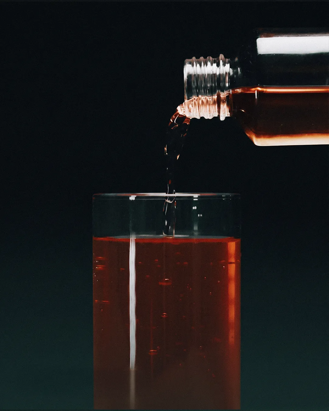 IVYH dropper pouring red liquid into a glass